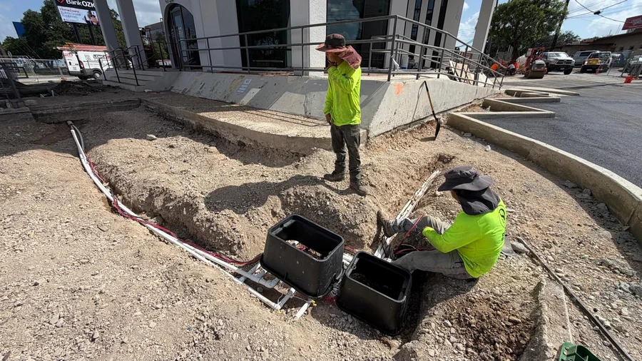 Design Scapes crew installing an irrigation valve box on a San Antonio commercial property