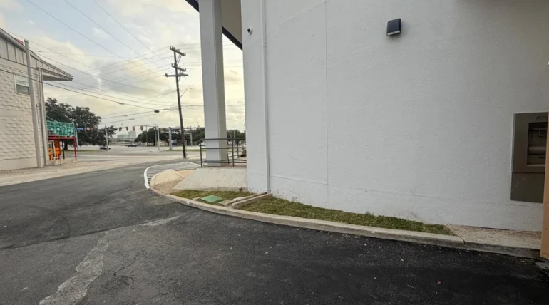 Curbed landscape bed running beside a commercial walkway in San Antonio