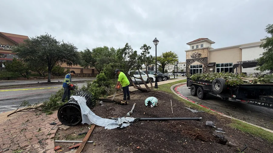 A Design Scapes crew unloading bed material at a San Antonio commercial property, the labor and materials that make up a commercial grounds maintenance cost